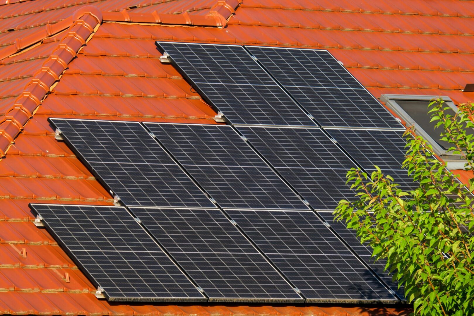 A red tile roof with solar panels on it.